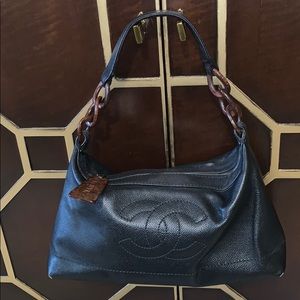 Chanel black caviar bag with zipper top closure.